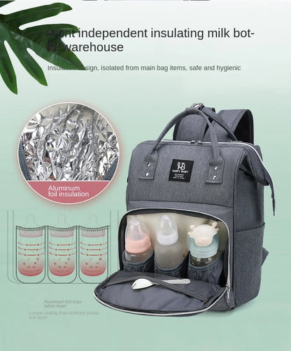 Diaper backpack alongside baby items – bottles, toys, and diapers – organized bag