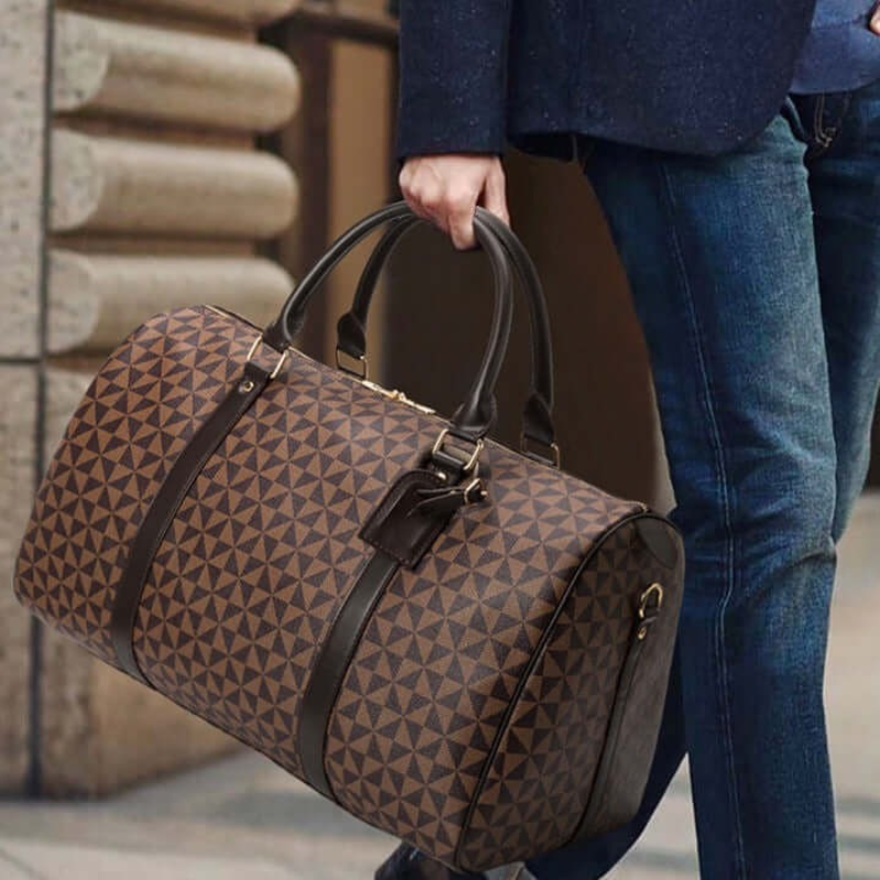 Model carrying a sleek black unisex duffle bag, showcasing its comfortable design for travel & gym. Stylish everyday carry.