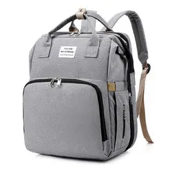 Multi-functional baby travel backpack, features a folding changing pad and USB charging.