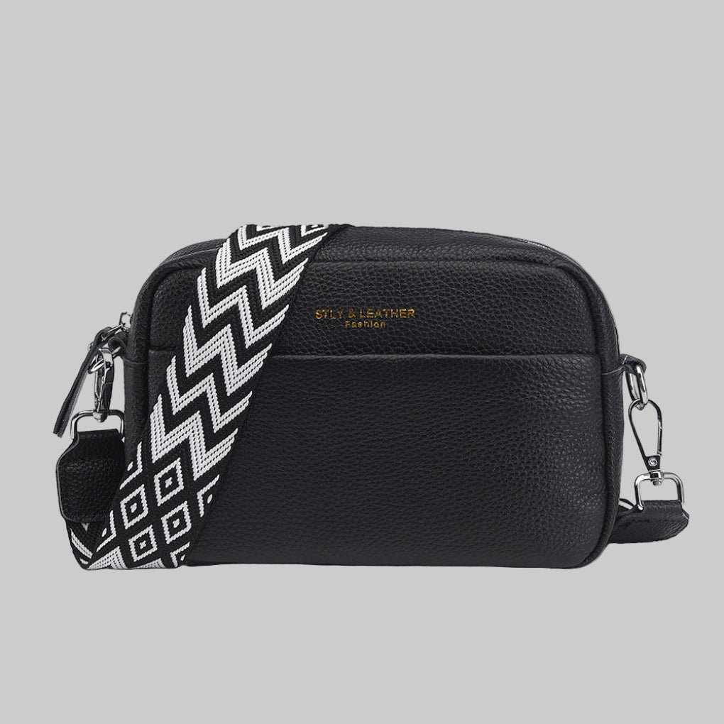 Stylish women's black crossbody bag featuring a unique geometric shoulder strap. Versatile everyday fashion accessory.
