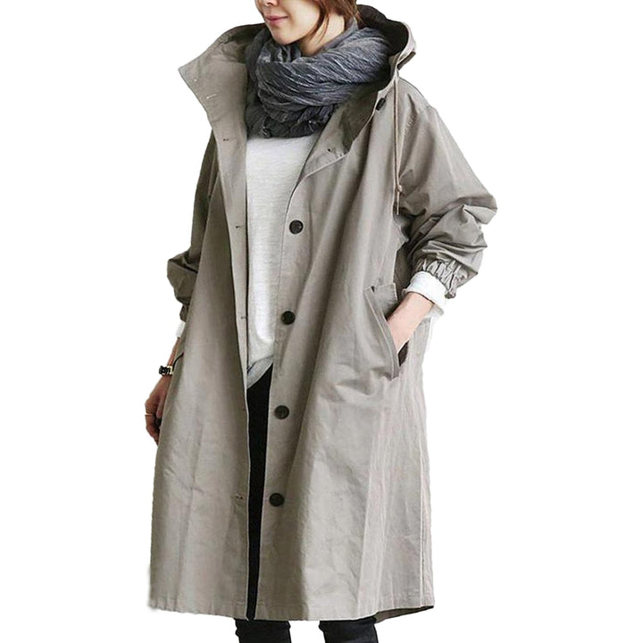 Woman walking in a fashionable hooded waterproof long raincoat, ideal for city & outdoor adventures.