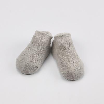 Detail view of the anti-slip silicone grips on the sole of a baby mesh cotton sock