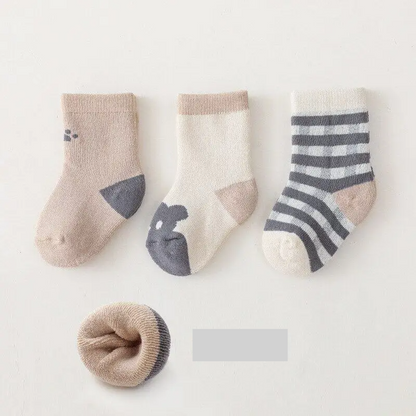 Three pairs of durable baby socks designed for warmth and comfort in cold seasons, infant apparel