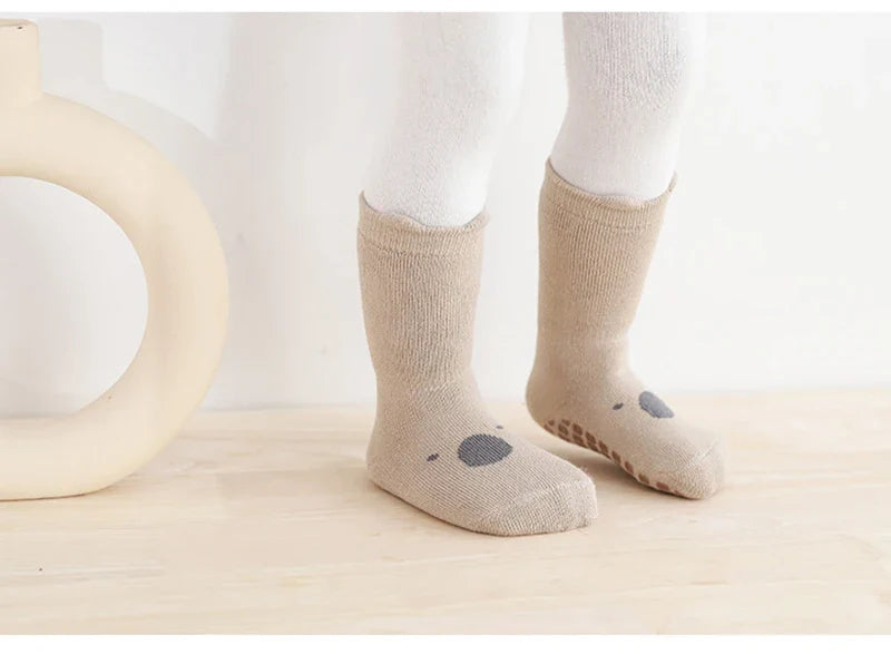 Closeup of anti-slip dots on the sole of a colorful cartoon unisex baby sock for winter