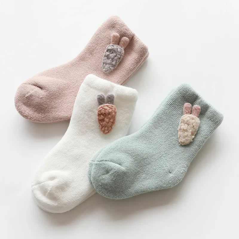 Three pairs of warm winter baby socks with cute animal designs, perfect for infants and toddlers.