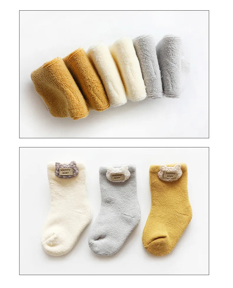 Three pairs of cute animal baby socks in white, red, and blue, showcasing delightful designs.