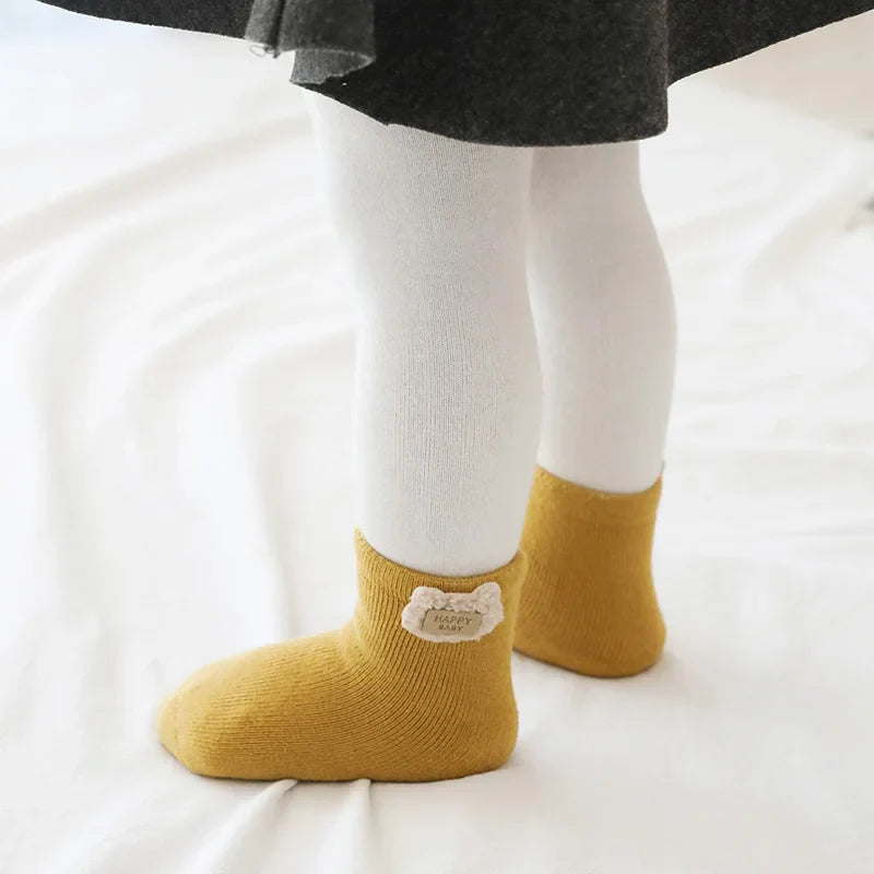 Close-up of a pair of soft cotton blend baby socks with an adorable bear face and ears design.