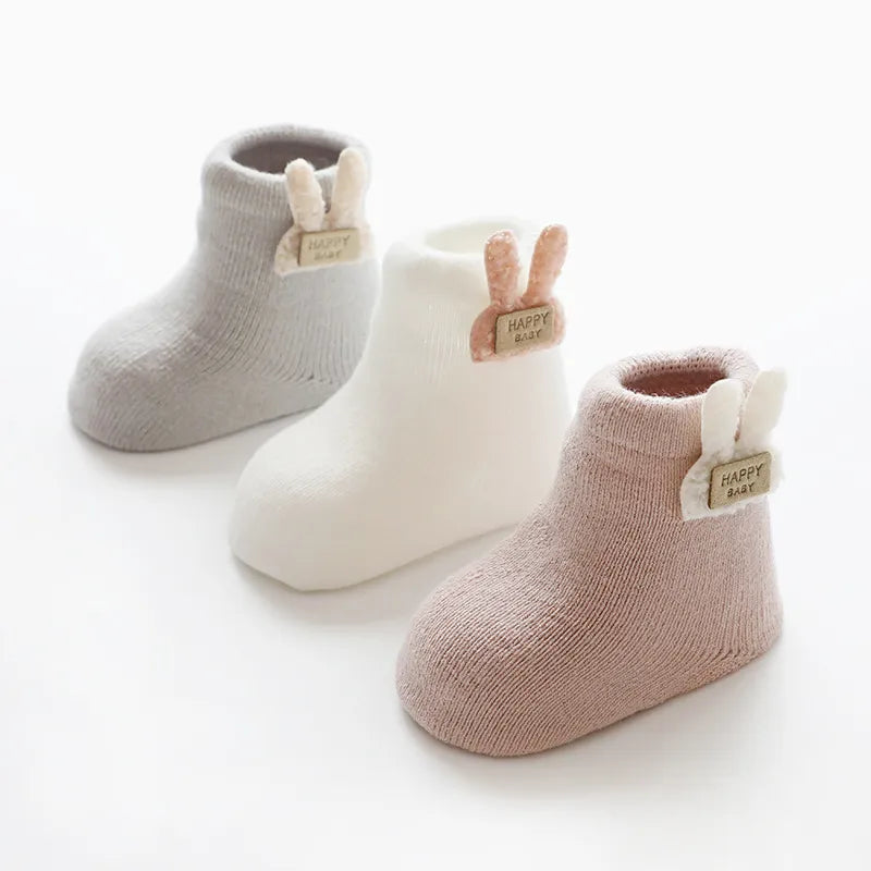 Textured image of cotton blend baby socks in a three-pack, highlighting the cute animal designs.