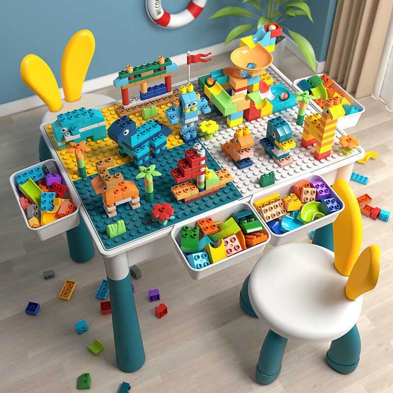 Toddler activity table with storage, complete with two chairs and building blocks, perfect for preschool learning.