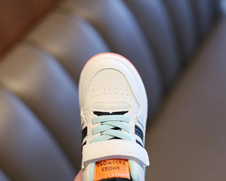 Kids' shoes with elastic laces and hook-and-loop closure, illustrating easy on/off feature
