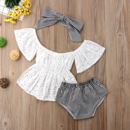 Cute infant girl's 3-piece summer set: lace top, patterned shorts, and bow headband on white background