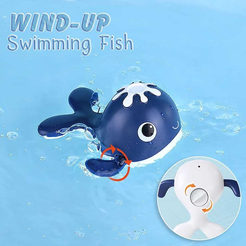 Child's hand holding magnetic rod catching a wind-up whale in a bath fishing game