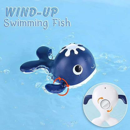Child's hand holding magnetic rod catching a wind-up whale in a bath fishing game