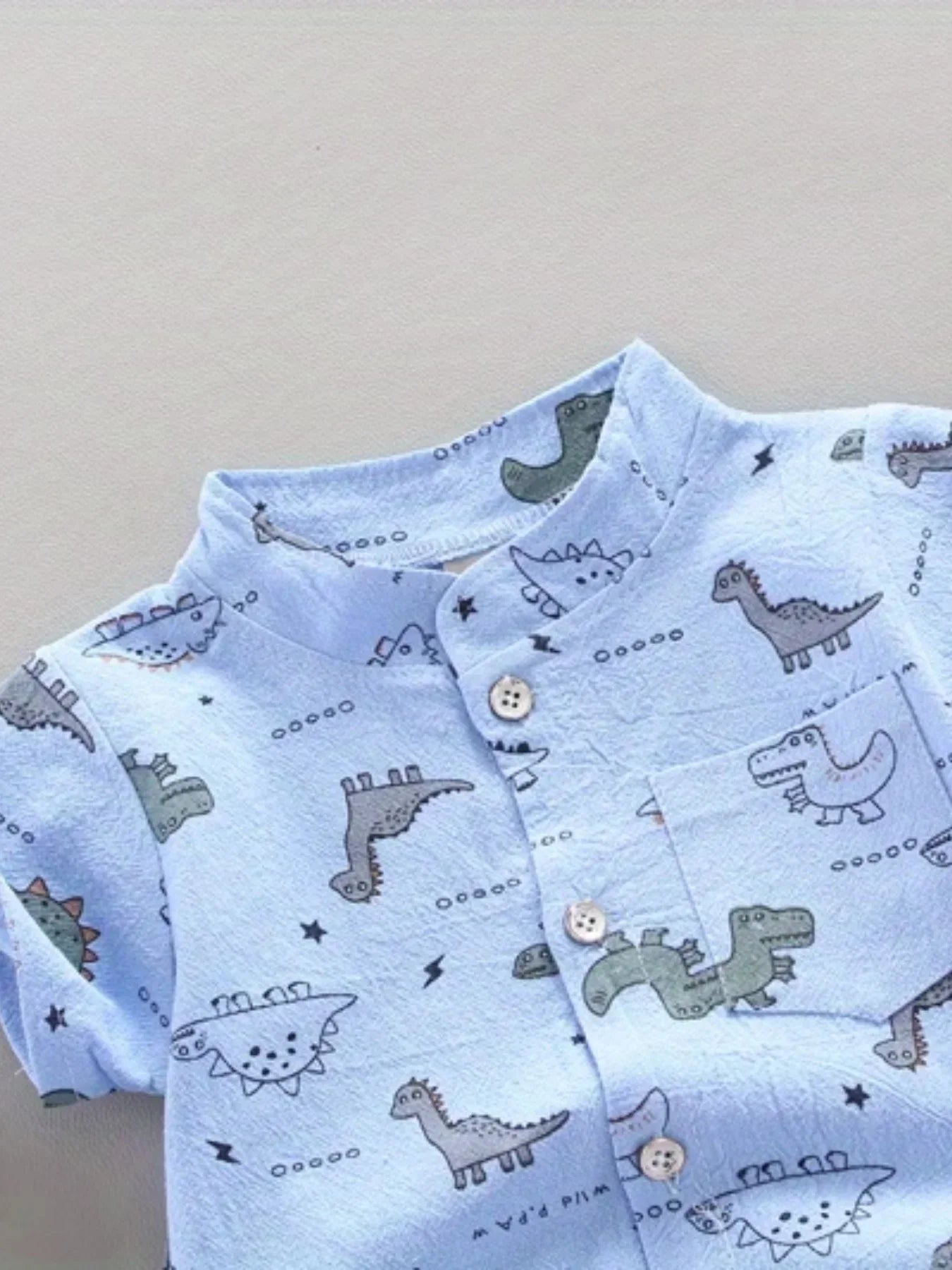 Boys' summer play outfit featuring a vibrant dinosaur graphic tee and solid blue shorts