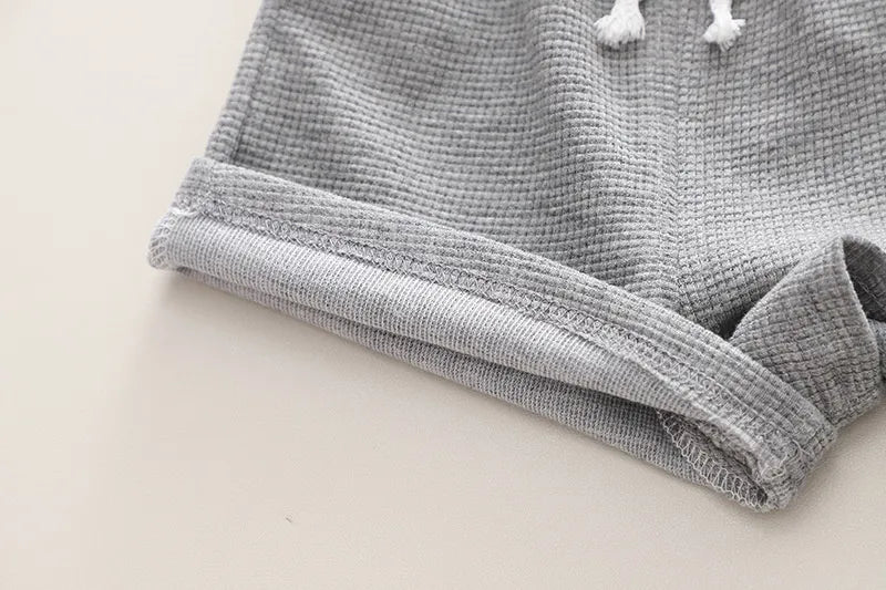 Front detail of the blue sleeveless top for toddler boys, with a simple yet stylish design for summer activewear.