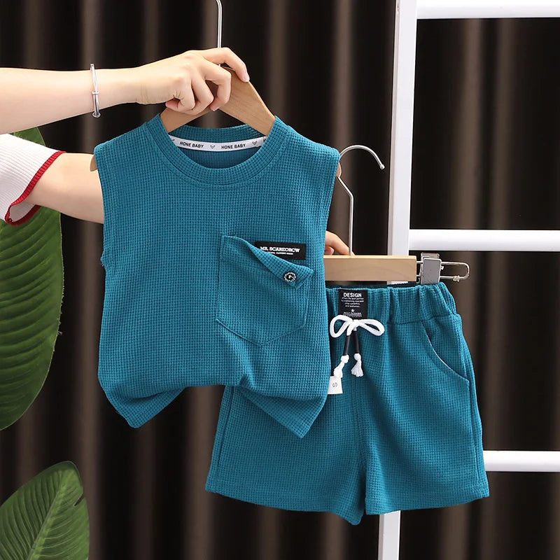 Close-up of soft cotton fabric of toddler boy's sleeveless top, blue with white trim, for summer play clothes.