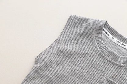 Close-up of the elastic waistband and drawstring on the orange toddler boys' sports shorts, practical and comfy.