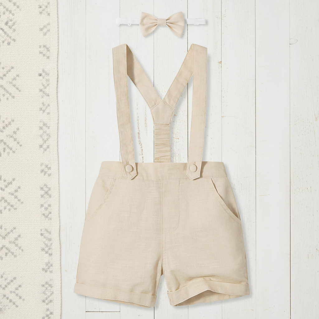 Adorable toddler boy dressed in a charming cotton shorts set with fashion-forward suspenders and a classic bow tie