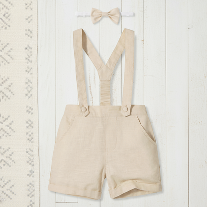 Adorable toddler boy dressed in a charming cotton shorts set with fashion-forward suspenders and a classic bow tie