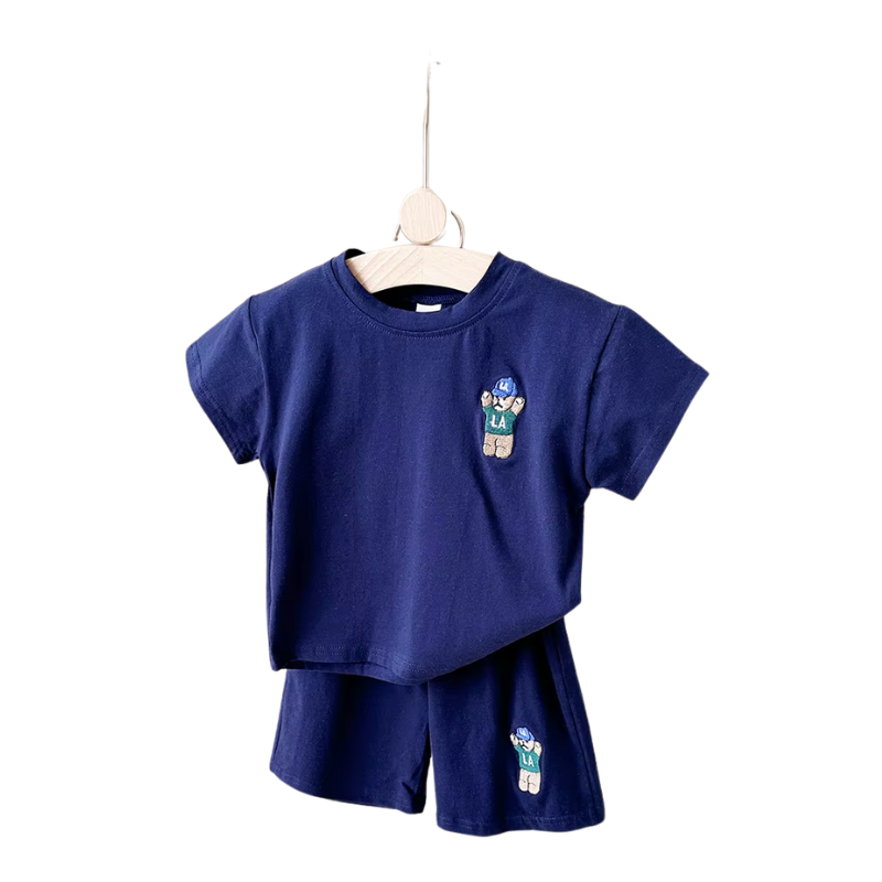 Happy toddler boy wearing a breathable cotton blend urban bear summer outfit, great for active playwear.