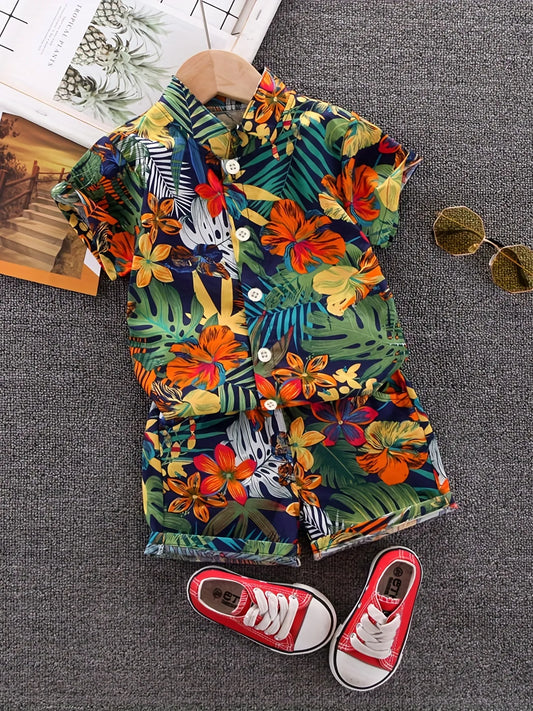 Toddler boy in white short-sleeve top with green leaf print & matching shorts, perfect summer playwear.
