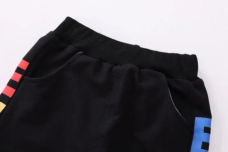 Blue cotton outfit for toddler boys, long-sleeve t-shirt and casual pants, hanging on a hanger.