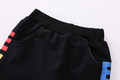 Blue cotton outfit for toddler boys, long-sleeve t-shirt and casual pants, hanging on a hanger.