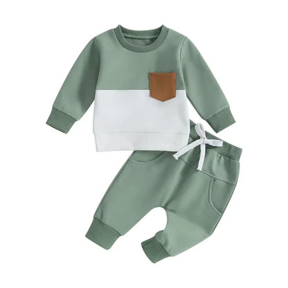 Toddler boy confidently modeling a trendy black cotton blend tracksuit set, casual and warm