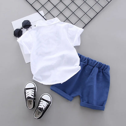 Close-up of the dinosaur print on the toddler boys' summer shirt and shorts set