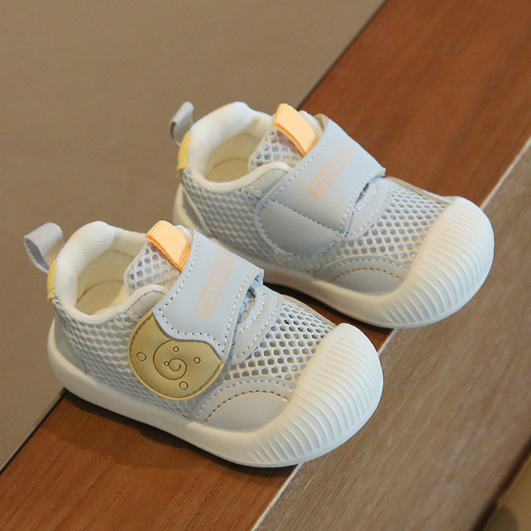 White toddler's breathable mesh first walker sneakers, featuring a secure closure for a snug fit.