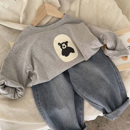 Close-up of a kids' bear print cotton sweatshirt, showing detailed animal graphic and fabric texture.