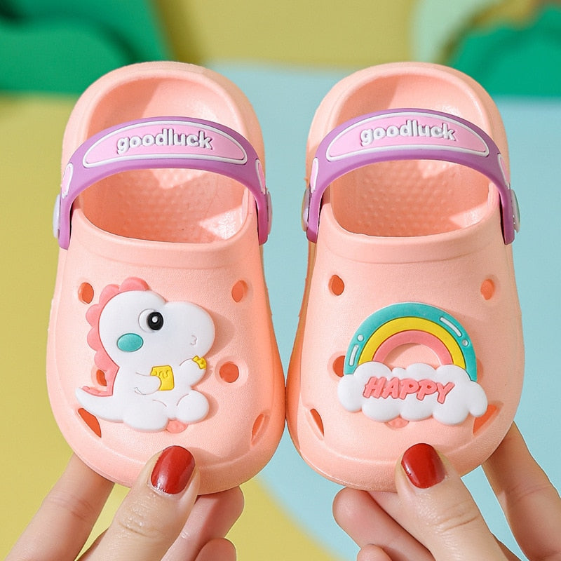 Close-up of baby croc sandals with dinosaur spikes on strap, comfortable fit