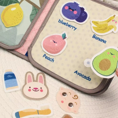 Infant playing with soft educational busy book, exploring textures & colors, early learning toy