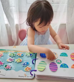Preschool child focused on an educational activity book, boosting cognitive development and learning.