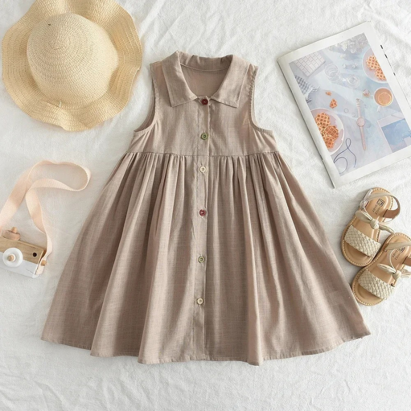 Toddler girl in a beige button-front summer whimsy dress for playtime fashion.