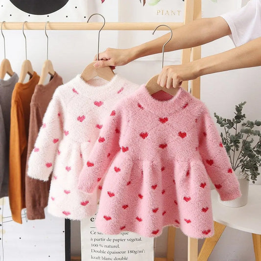 Toddler girl in a cozy pink fleece winter dress, perfect for stylish warmth in cold weather.