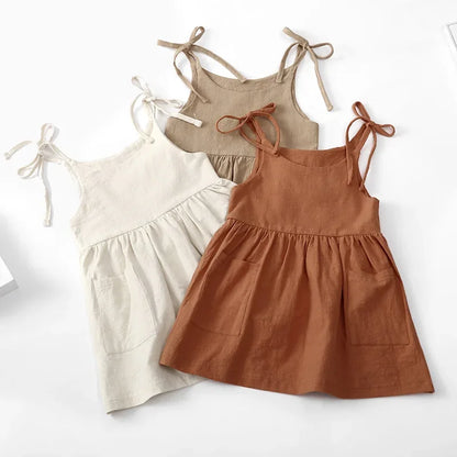 Closeup of soft, lightweight cotton fabric on a toddler girls' sleeveless dress, ideal for warm weather.