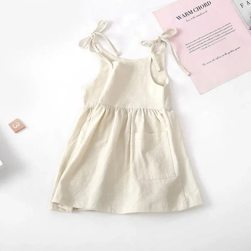 Happy toddler girl wearing a comfortable and breathable yellow cotton sleeveless dress, kids fashion.