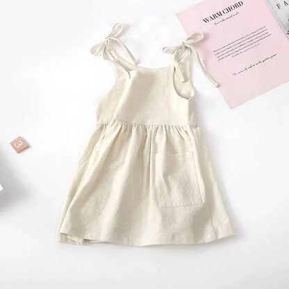 Happy toddler girl wearing a comfortable and breathable yellow cotton sleeveless dress, kids fashion.