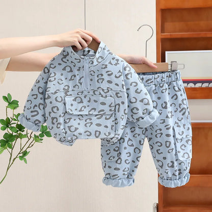 Close-up of leopard print fabric on a kids' two-piece sweatshirt and pants set, soft texture.