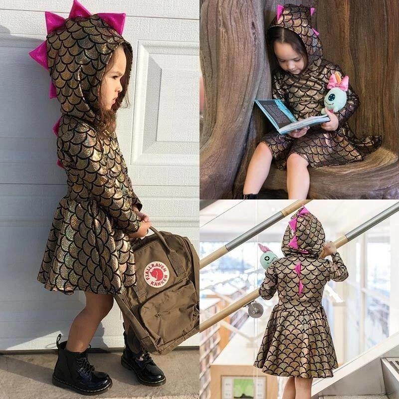 Toddler girl in pink shimmer dinosaur hooded dress, perfect for playful kids fashion.