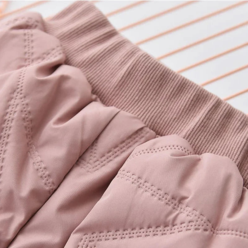 Close-up of waterproof zipper and snap closure on kids' winter snow pants.