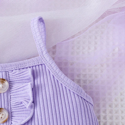 Young girl happily twirling in a purple princess dress, showcasing a play dress style