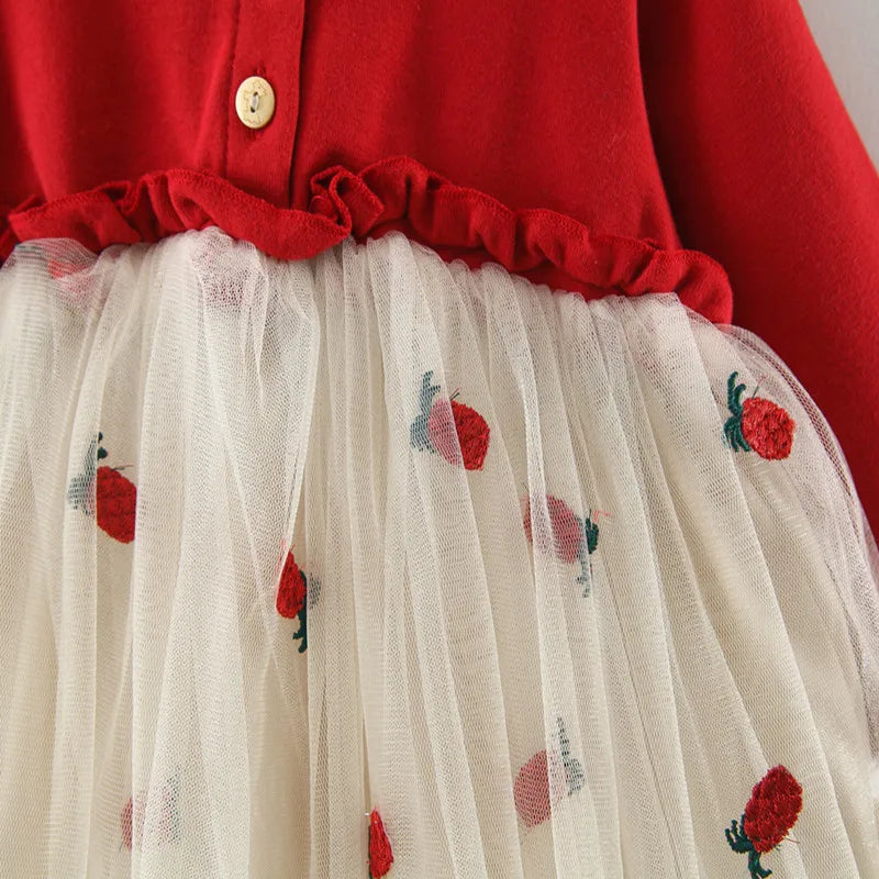 Infant girl smiling, wearing a beautiful red long sleeve lace tutu dress for special occasions.