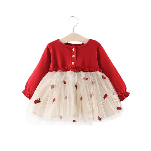 Little girl twirling in an elegant red lace long sleeve dress, suitable for celebrations.