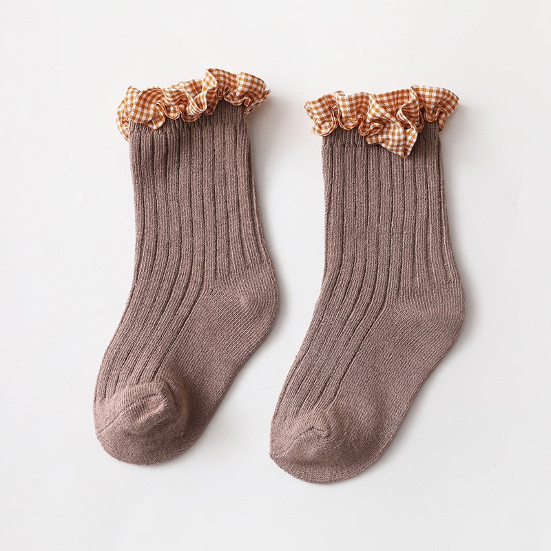 Close-up view of the elastic cuff on pink and white checkered knit ankle socks for toddlers