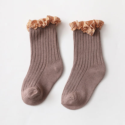 Close-up view of the elastic cuff on pink and white checkered knit ankle socks for toddlers