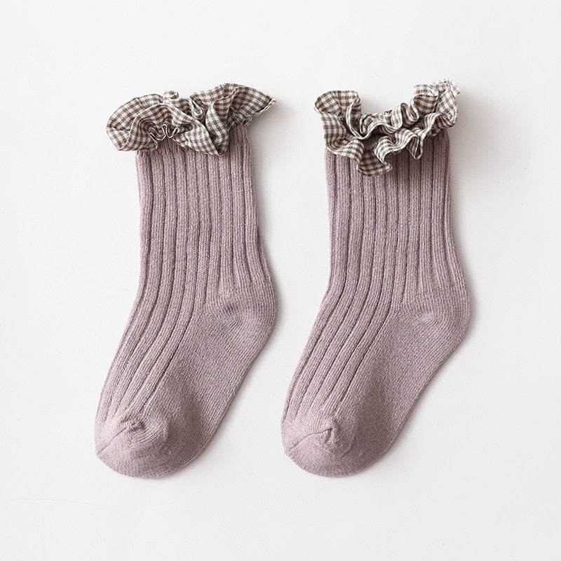 Pair of baby girl's cotton knit ankle socks with a playful pink and white checkered design
