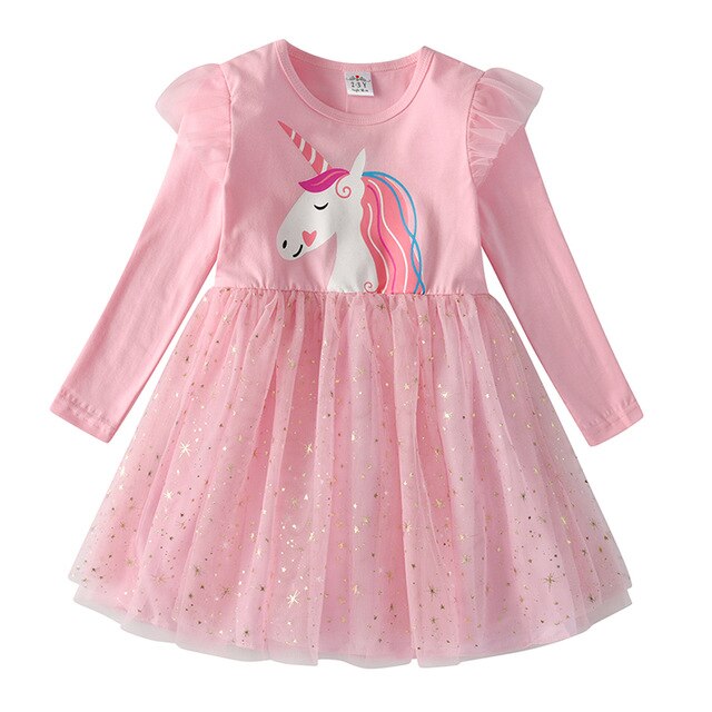 Young girl happily twirling in a festive snowflake long sleeve mesh dress, holiday fashion.