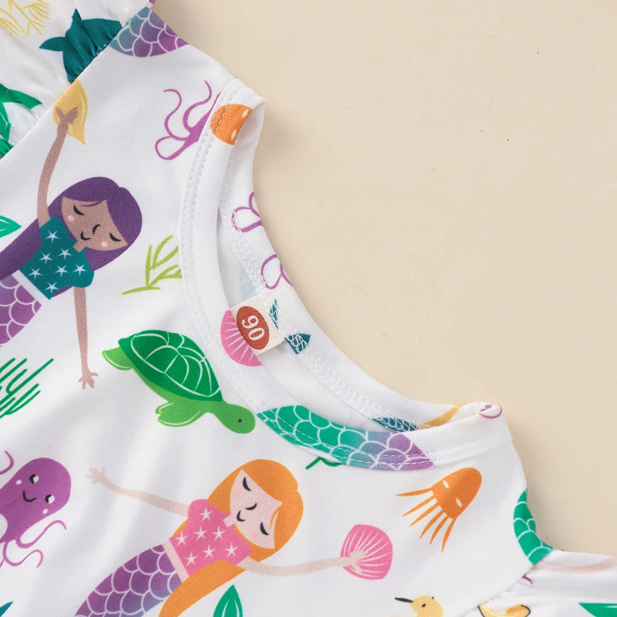 Close-up of mermaid print on a child's ruffled sleeveless A-line summer dress